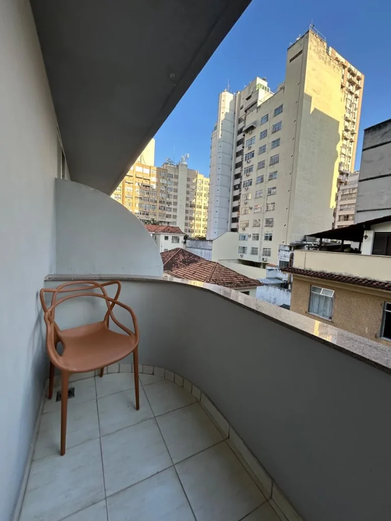 Varanda do Standard Superior Twin com cadeira e vista dos prédios de Icaraí